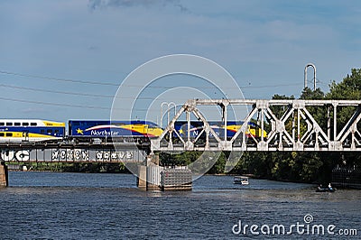 MINNEAPOLIS, MN â€“ SEPTEMBER 9, 2018: Northstar Commuter Train moves east across bridge over Mississippi river. The Northstar Editorial Stock Photo